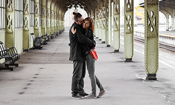 Two Lovers hug and kiss at railway station